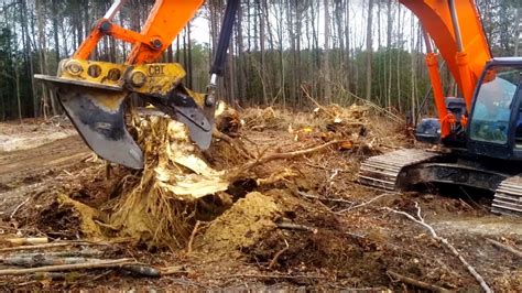 photo of skid steer excavator removed a downed tree rootball|stump removal machine.